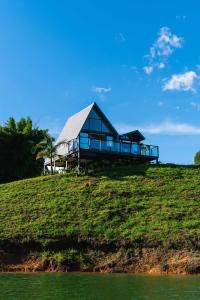 a house on top of a hill next to the water at 5CHALETS in Guatapé