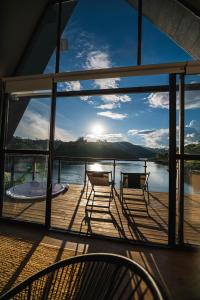 una terraza con sillas y vistas al agua en 5CHALETS, en Guatapé