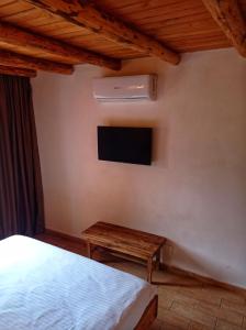 a bedroom with a bed and a tv and a table at Zorra Challet in Eşelniţa