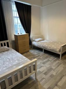 a bedroom with two beds and a dresser and a window at Central London location, close to bars restaurants and train stations in London