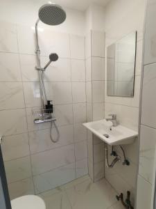 biała łazienka z umywalką i prysznicem w obiekcie Guest House Stojanoski w Ochrydzie