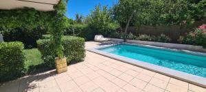 - une piscine dans une cour à côté d'une maison dans l'établissement Studio le Cèdre avec piscine au calme, à Mimet