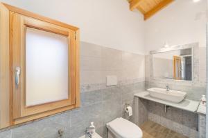 ein Badezimmer mit einem Waschbecken, einem WC und einem Spiegel in der Unterkunft Casa Blanca in Buggerru