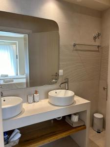 a bathroom with two sinks and a large mirror at Corfu valley view in Paleokastritsa