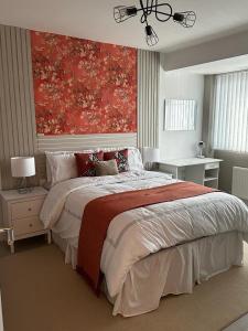 1 dormitorio con 1 cama grande y una pintura roja en la pared en Modern 3 Bedroom home near Birmingham Airport & NEC, en Sheldon