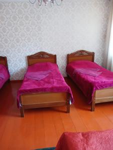 two beds in a room with pink sheets on them at Guest house Track Kazbegi in Kazbegi