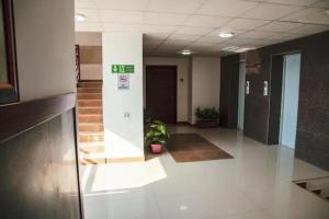 a hallway of an office building with a clock on the wall at Ghumo - 3BR APT Main Shahrah-e-Faisal in Karachi