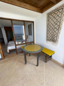 a room with a table and a bench and a bed at Aftas beach house in Taghazout