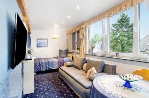 ein Wohnzimmer mit einem Sofa, einem Bett und einem Fenster in der Unterkunft Flair Ferienwohnung Lilie in Stockach