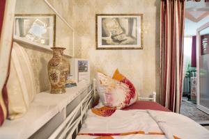 una camera con un letto e un vaso su una mensola di Flair Ferienwohnung Orchidee a Stockach