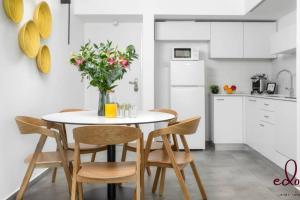 a kitchen with a table with chairs and a vase of flowers at דירה משפחתית מרווחת במתחם סי סייד - By Edomlux in Eilat