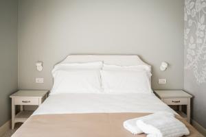 a white bed with white sheets and pillows on it at Villa Dafne Valpolicella B&B Adults only, no smoking, no pets in SantʼAmbrogio di Valpolicella