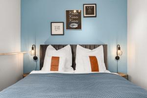 Maracoon - Suite Apartments Essen Messe I Great location في إيسن: غرفة نوم مع سرير مع وسائد برتقالية وبيضاء