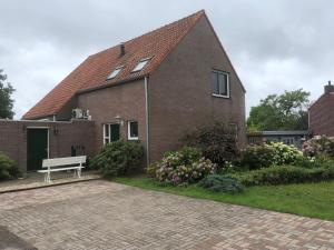a brick house with a bench in front of it at Laaker Villa nearby outlet Roermond in Ohé en Laak