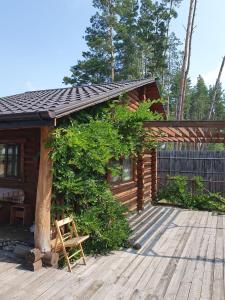 a log cabin with a bench on a deck at Eco dom v lesu in Bila Krynytsya