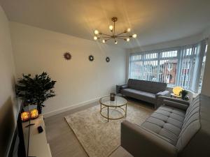 a living room with a couch and a table at Modern 3 Bedroom home near Birmingham Airport & NEC in Sheldon