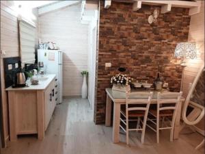 uma cozinha com uma mesa e uma parede de tijolos em דירת חדר נעימה במיקום פסטורלי em Quriate-Chemoná