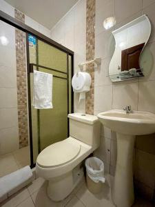 a bathroom with a toilet and a sink at Hostal Bicentenario in Guayaquil