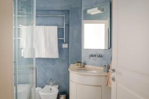 a bathroom with a sink and a toilet and a mirror at Villa Dafne Valpolicella B&B Adults only, no smoking, no pets in SantʼAmbrogio di Valpolicella +11 photos