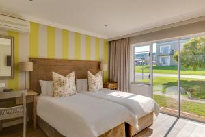 a bedroom with a large bed and a large window at Protea Hotel by Marriott Stellenbosch & Conference Centre in Stellenbosch