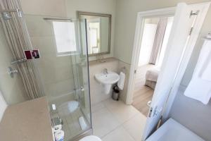 a bathroom with a shower and a toilet and a sink at Protea Hotel by Marriott Stellenbosch & Conference Centre in Stellenbosch