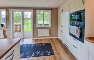 uma cozinha com armários brancos e um tapete azul em Lovely Home In Kllby With Wifi em Källby