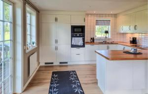 uma cozinha com armários brancos e um aparelho preto em Lovely Home In Kllby With Wifi em Källby