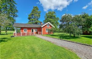 uma casa vermelha com um grande quintal em Lovely Home In Kllby With Wifi em Källby