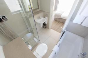 a bathroom with a shower and a toilet and a sink at Protea Hotel by Marriott Stellenbosch & Conference Centre in Stellenbosch