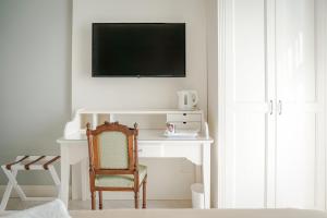 a white desk with a chair and a television on a wall at Villa Dafne Valpolicella B&B Adults only, no smoking, no pets in SantʼAmbrogio di Valpolicella