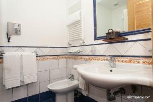 ein Badezimmer mit einem Waschbecken, einem WC und einem Spiegel in der Unterkunft Le Mandrelle Beach Resort in Amantea