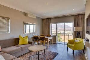 a living room with a couch and a table and chairs at Protea Hotel by Marriott Stellenbosch & Conference Centre in Stellenbosch
