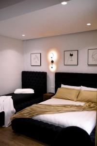 una camera con letto e testiera nera di Hotel Olsi a Sarandë