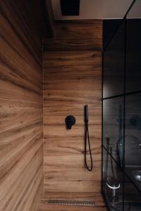 a shower in a bathroom with a wooden wall at Hotel Olsi in Sarandë