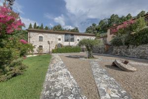 an exterior view of a stone house with a garden at Al Frantoio in Corsanico-Bargecchia