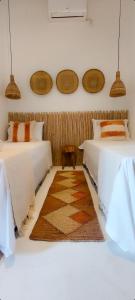 um quarto com duas camas e um tapete no chão em Afeto Caraíva em Caraíva