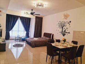a living room with a bed and a table with chairs at Bali Residence Melaka Condo in Malacca