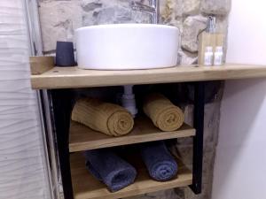 a bathroom shelf with a sink and towels at studio entre terre et ciel - escapade millavoise in Millau