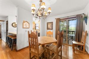 a dining room and kitchen with a wooden table and chairs at Nestled Inn Lodge Home in Branson West