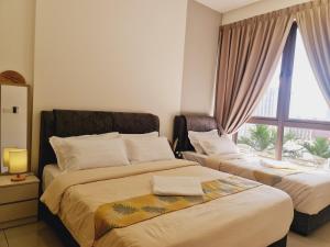 a bedroom with two beds and a window at Bali Residence Melaka Condo in Melaka
