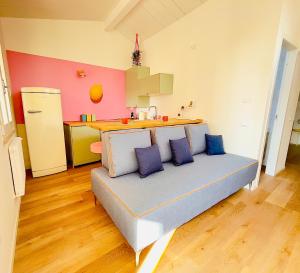 ein Wohnzimmer mit einer Couch mit blauen Kissen darauf in der Unterkunft TINTORIA - Manu Maison in Parma