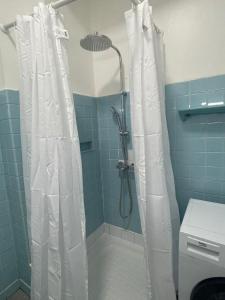 a shower with a white shower curtain in a bathroom at Appartement Marseille centre Terrasse Vieux Port in Marseille