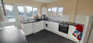 a kitchen with white cabinets and a dishwasher at Move inn Estates - Multiple Rooms in London