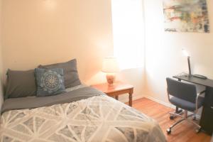 a bedroom with a bed and a desk and a chair at 3 BR Southside Loft - Amazing Location in Pittsburgh