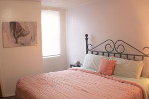 a bedroom with a bed with an orange blanket and a window at 3 BR Southside Loft - Amazing Location in Pittsburgh
