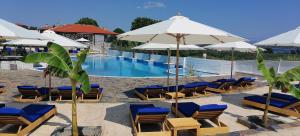 - une piscine avec des chaises longues et des parasols dans l'établissement Simon Prince Prive, à Vourvourou