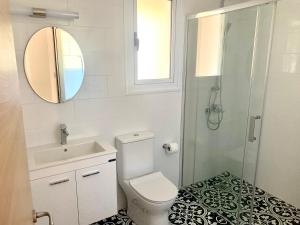een badkamer met een toilet, een wastafel en een spiegel bij Nissi3 B1 Lovely 1Bdr Ground Floor Apartment near Nissi Beach. in Ayia Napa