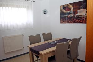 a dining room with a wooden table and chairs at Ferienwohnung Brandshagen in Reinberg +3 photos