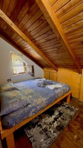 Cama en habitación con techo de madera en Guest House Aprripe Guri, en Fierzë