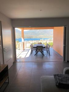 ein Esszimmer mit Tisch und Blick auf das Meer in der Unterkunft Casa campa lumba in Propriano